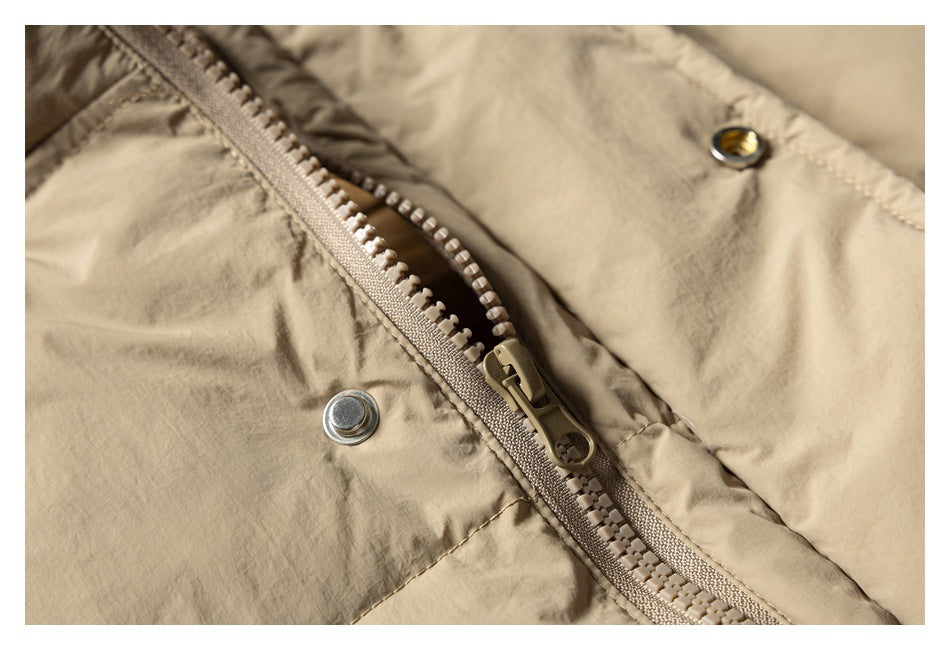 Close-up of the beige jacket's front zipper and metal snap fasteners.