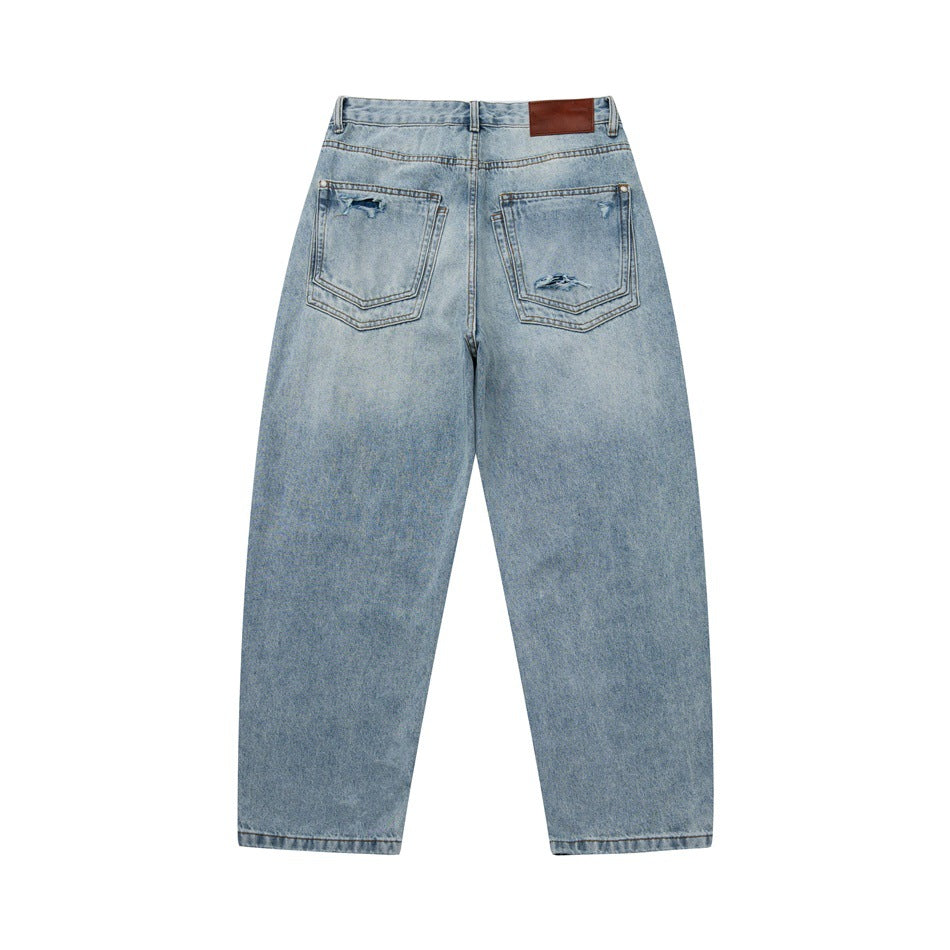 Back of light blue faded jeans with two distressed patch pockets and a brown waistband patch