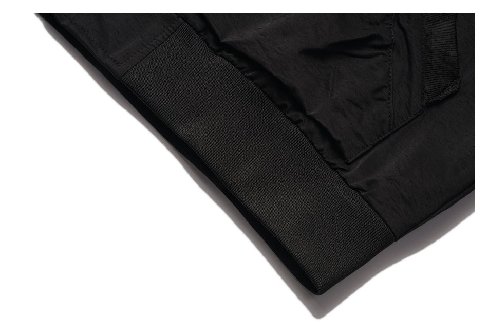 Close-up of the black jacket's wide ribbed hem and adjacent pocket seam.