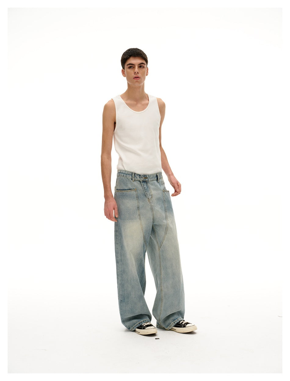 Model wearing a white tank top and oversized light-wash jeans, shown at a relaxed three-quarter front angle.