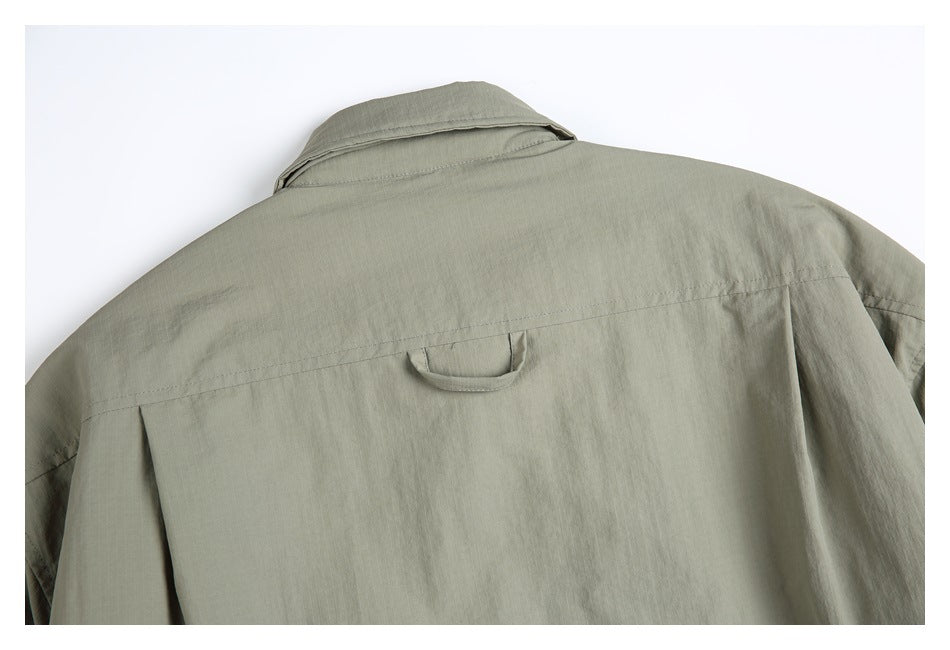 Upper back of a sage-gray shirt, showing the collar, shoulder yoke, and a small hanging loop.