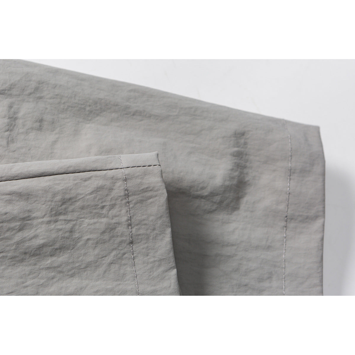 Close-up of gray shorts fabric and stitched seam near the hem.