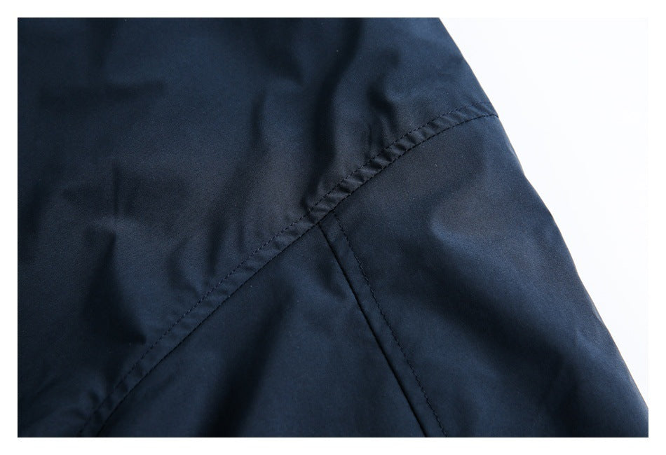 Close-up of intersecting stitched seams on dark navy garment fabric.