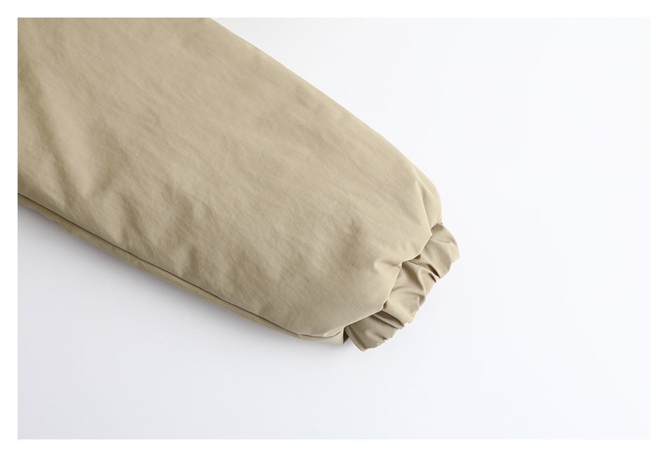 Close-up of a beige sleeve ending in a gathered elastic cuff.