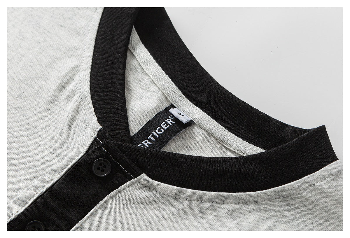 Close-up of a heather-gray shirt's black ribbed neckline, button placket, and inner label.