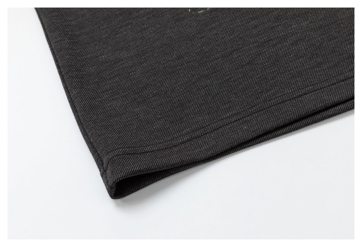 Close-up of dark fabric showing a folded, double-stitched hem.