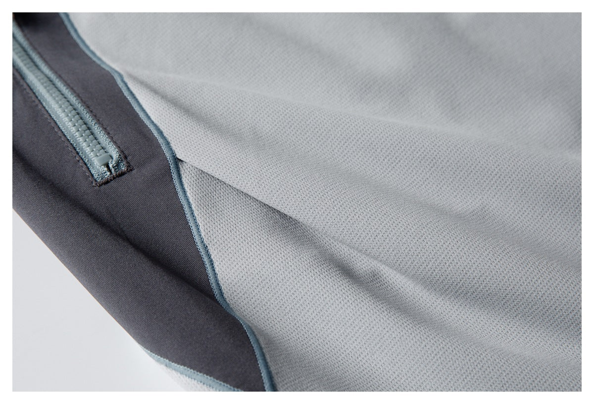 Close-up showing the pants' zip pocket, dark side panel, and light gray textured fabric.
