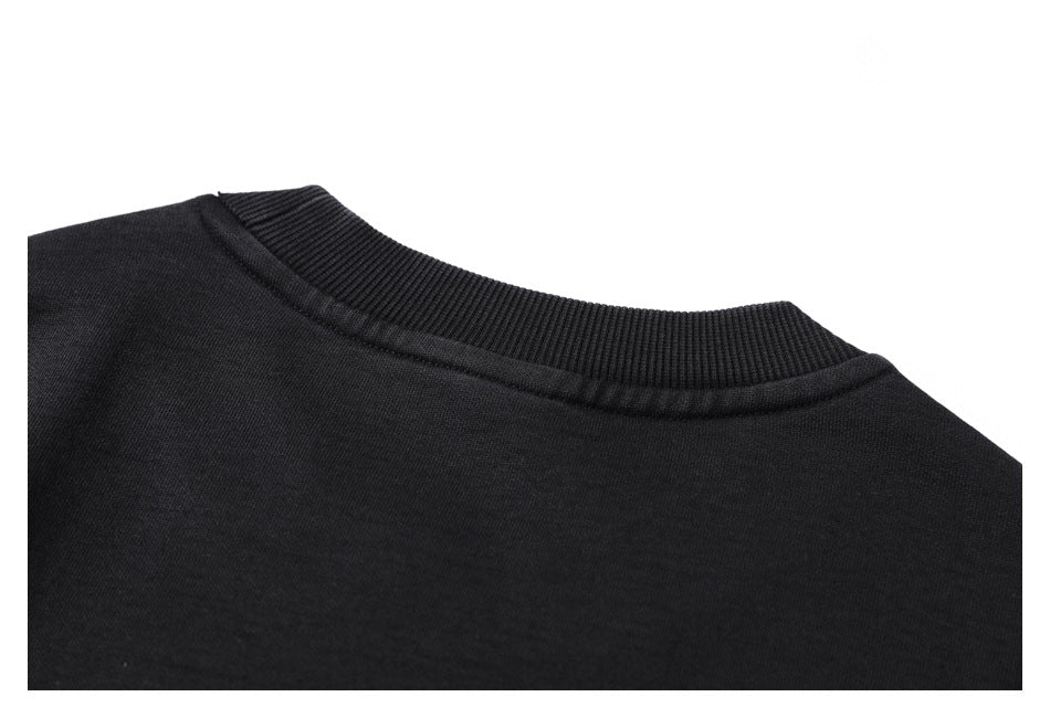 Close-up of the ribbed crew neckline and shoulder area of a black garment.
