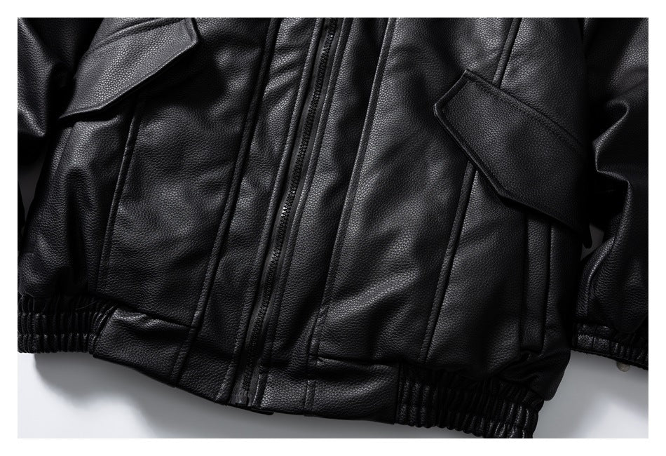 Close-up of a black jacket front with a central zipper, lapels, flap pockets and an elasticized hem.