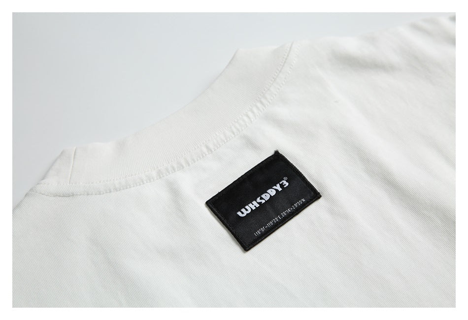 Close-up of the white garment's ribbed neckline and black sewn-in label.