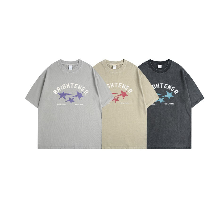 Three short-sleeve graphic T-shirts shown from the front in light gray, beige, and dark charcoal.