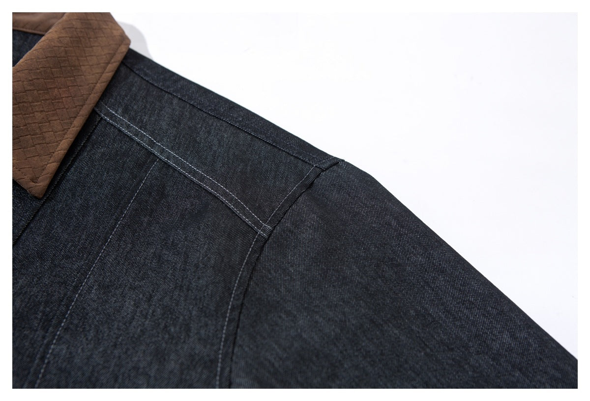 Close-up of the dark indigo jacket's shoulder and sleeve seam, with part of its brown collar visible.