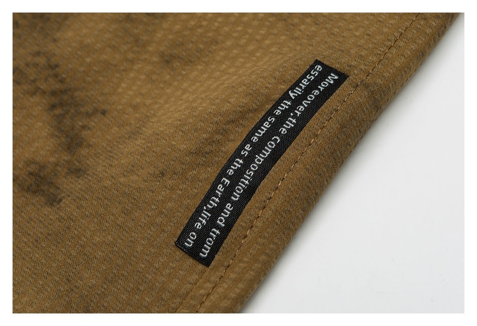 Close-up of a black sewn label with white English text on brown shorts.