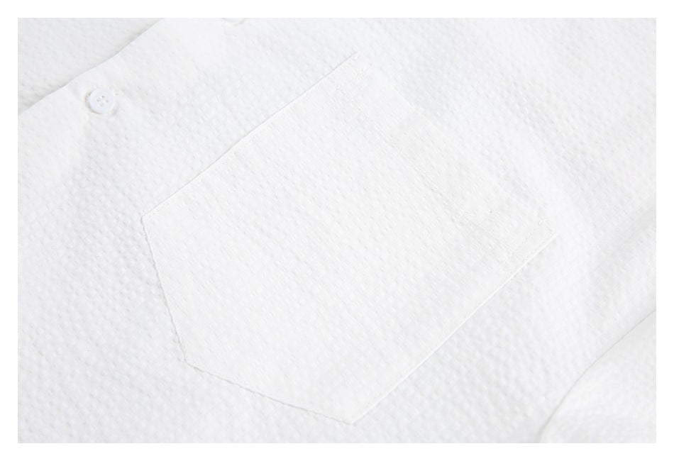 Close-up of a patch pocket on the white shirt's textured front.