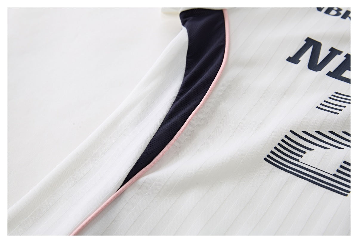 Close-up of a white pinstriped jersey showing navy side paneling with pink piping and part of its navy graphic.