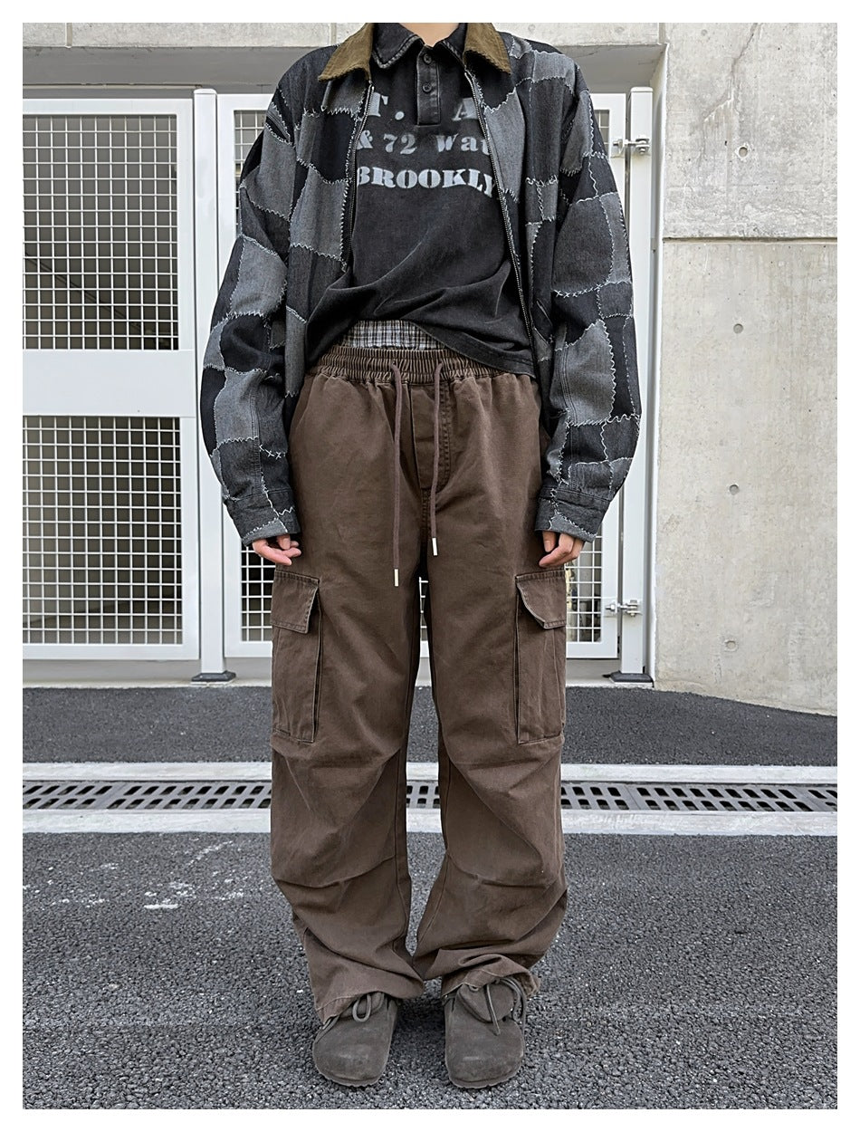 Person wearing brown wide-leg cargo pants with drawstring waist and flap pockets, styled with a patchwork denim jacket