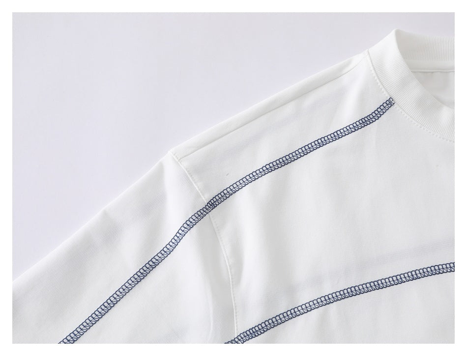 Close-up of a white shirt’s ribbed collar and shoulder, with navy overlock seam details.