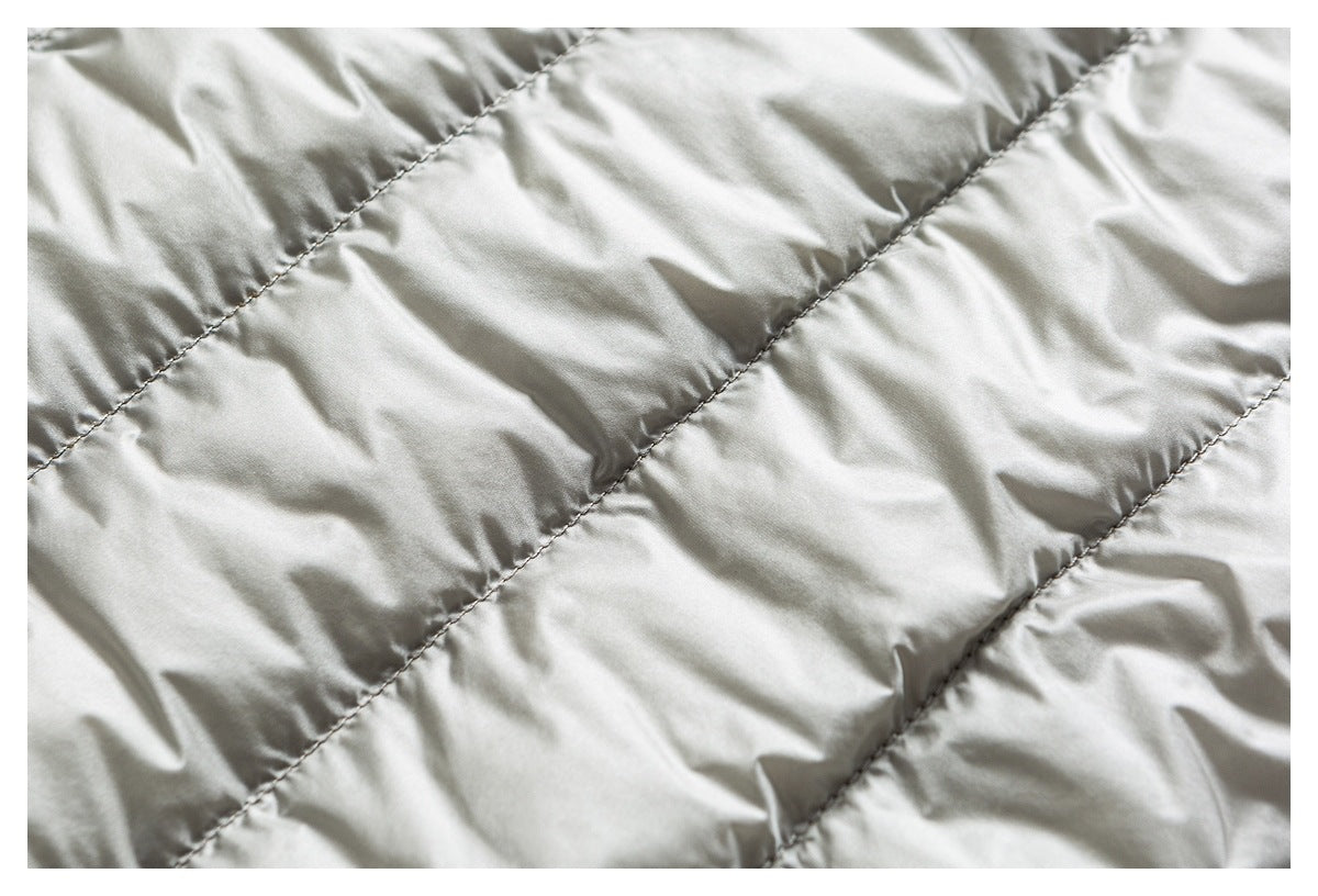 Close-up of pale quilted jacket lining with diagonal stitched channels.