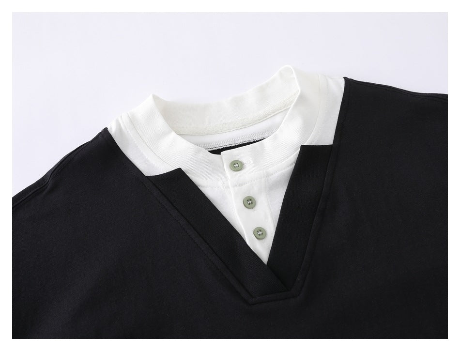 Close-up of the layered white collar and three-button placket framed by a black V-neck.