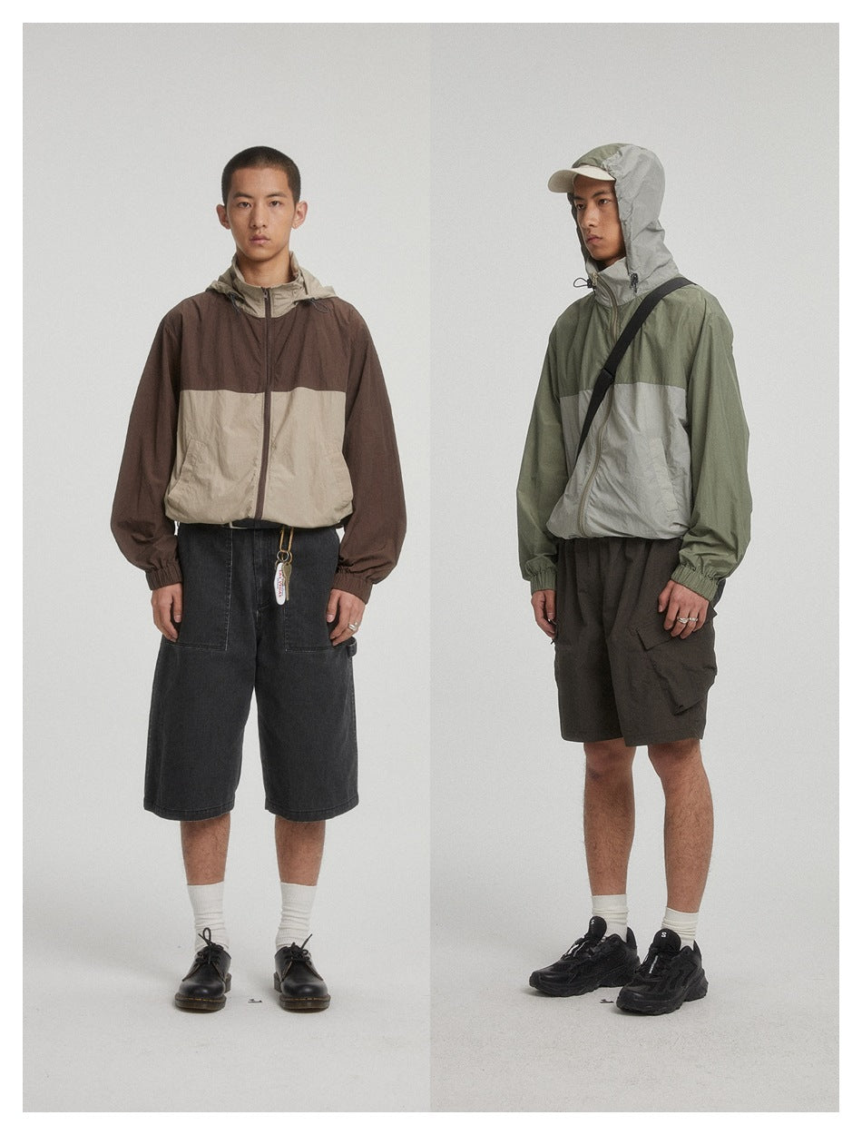 Two models in color-block hooded zip jackets, one brown and khaki, the other green and gray, with shorts