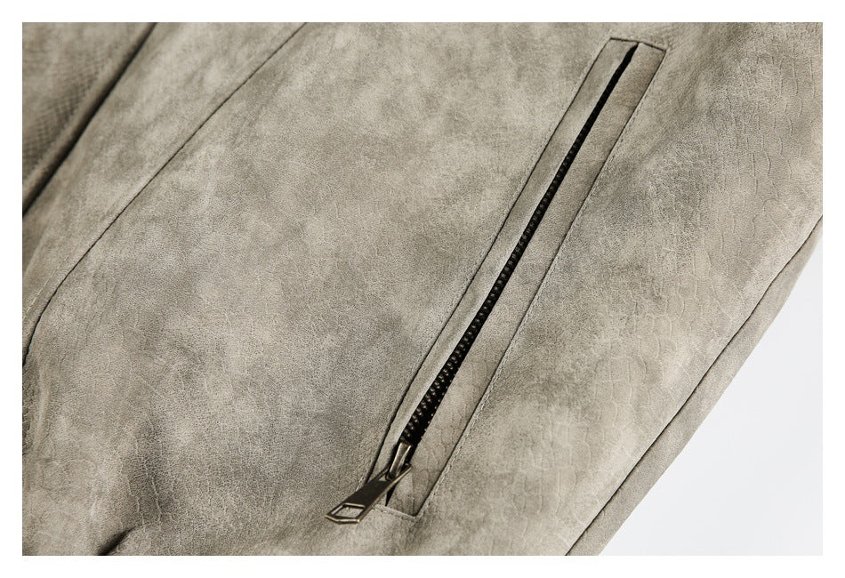 Close-up of a black zippered pocket on a taupe-gray jacket with a textured panel.