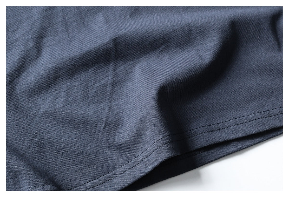 Close-up of the stitched bottom hem on slate-blue fabric.