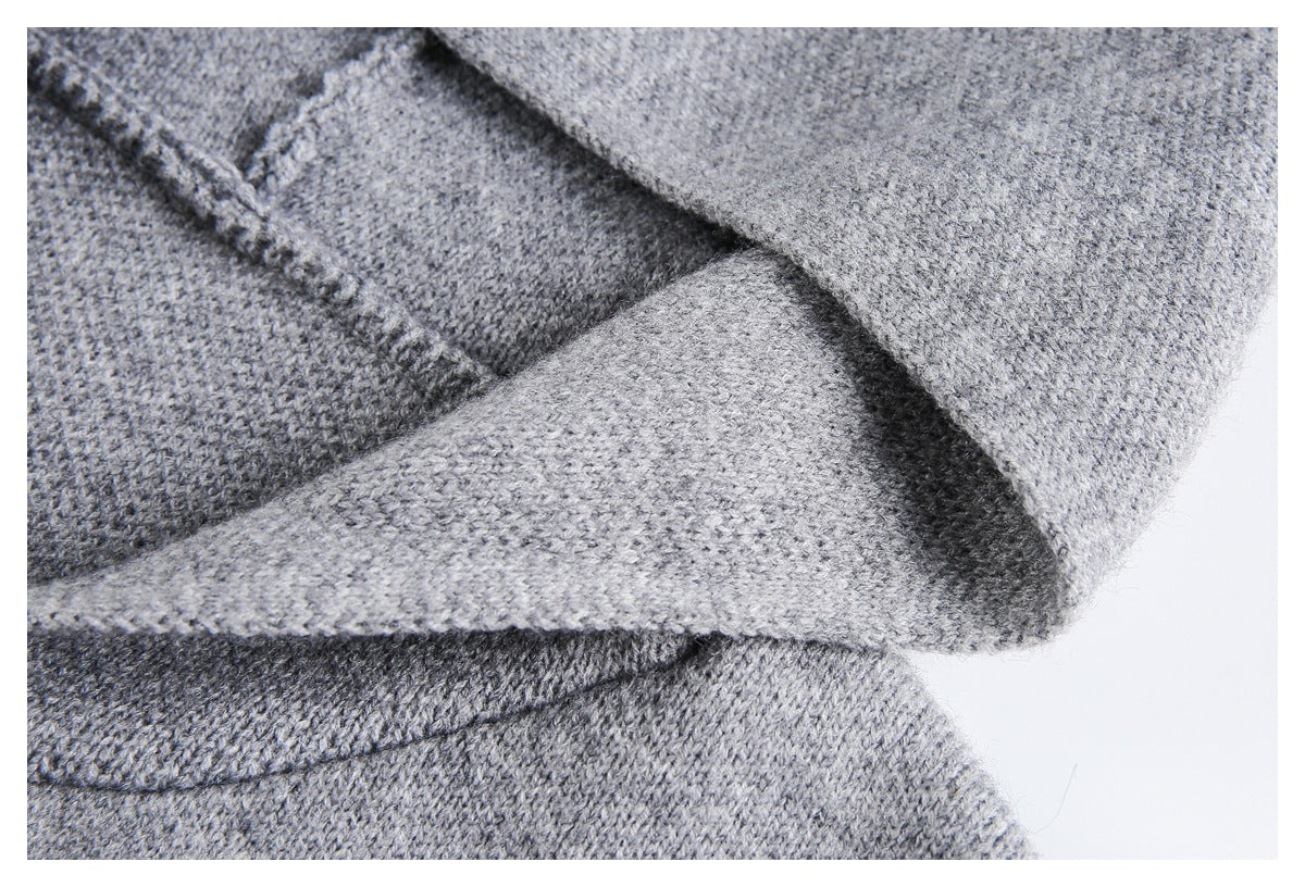 Close-up of gray knit fabric showing a folded edge and stitched seam.