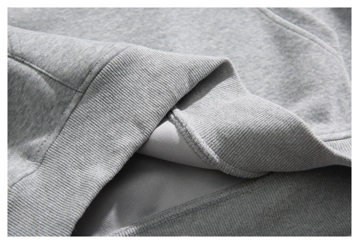Close-up of the gray hoodie’s ribbed hem and interior stitching.