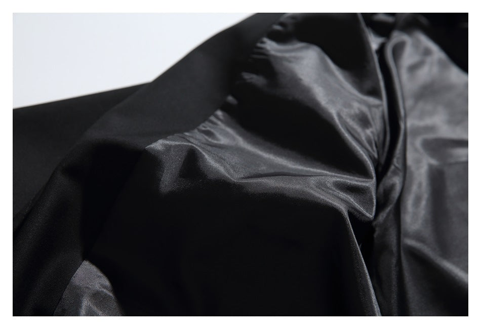 Close-up of a black blazer's interior, showing the smooth lining and folded outer fabric.