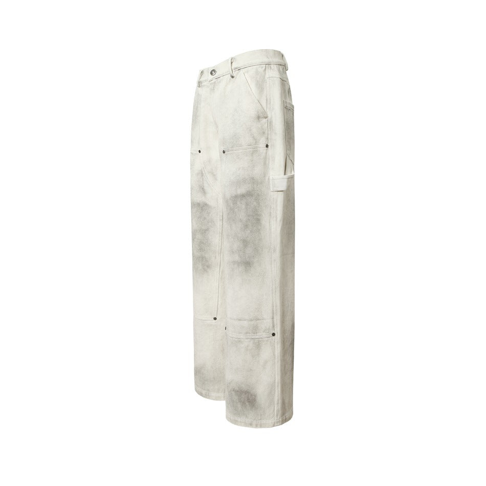 Angled front view of off-white wide-leg pants with gray mottling, a button waist, and stitched utility panels.