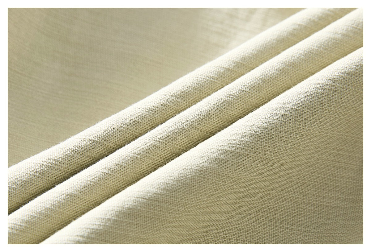 Macro view of pale beige woven jacket fabric folded into diagonal ridges.