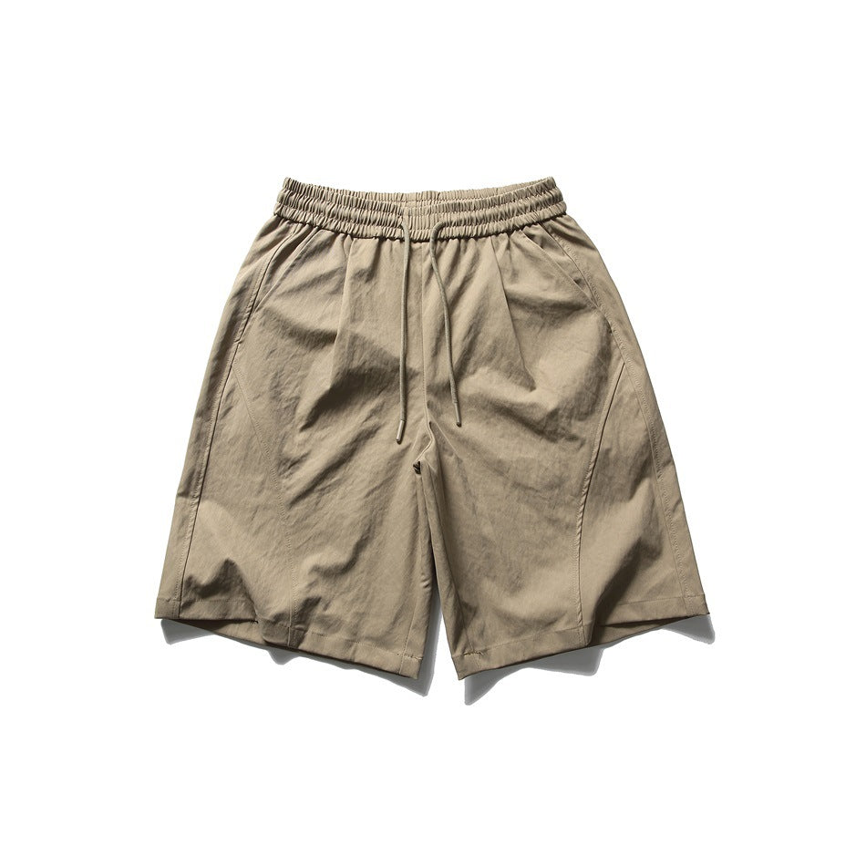 Khaki knee-length shorts with elastic drawstring waist, curved front seams and side pockets, flat lay front view
