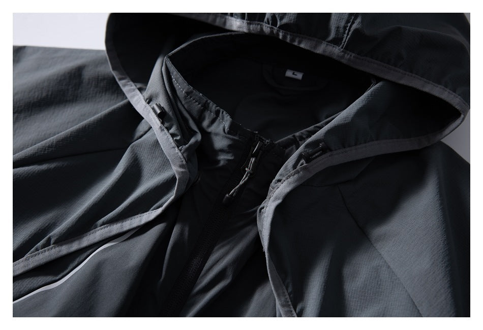 Close-up of a dark charcoal hooded jacket showing the hood lining, front zipper and drawcords.