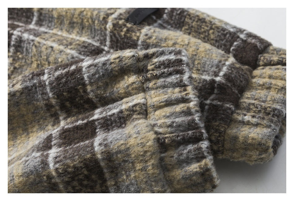 Close-up of a ribbed cuff on a brown, charcoal and tan plaid jacket.