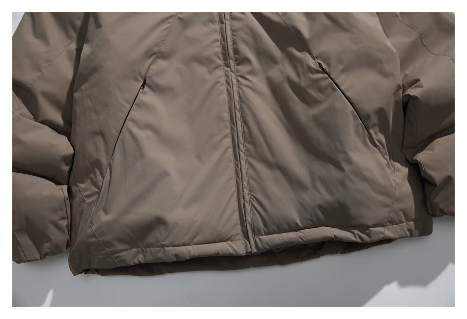 Close-up of the jacket’s lower front, showing the central zipper and two slanted zip pockets.