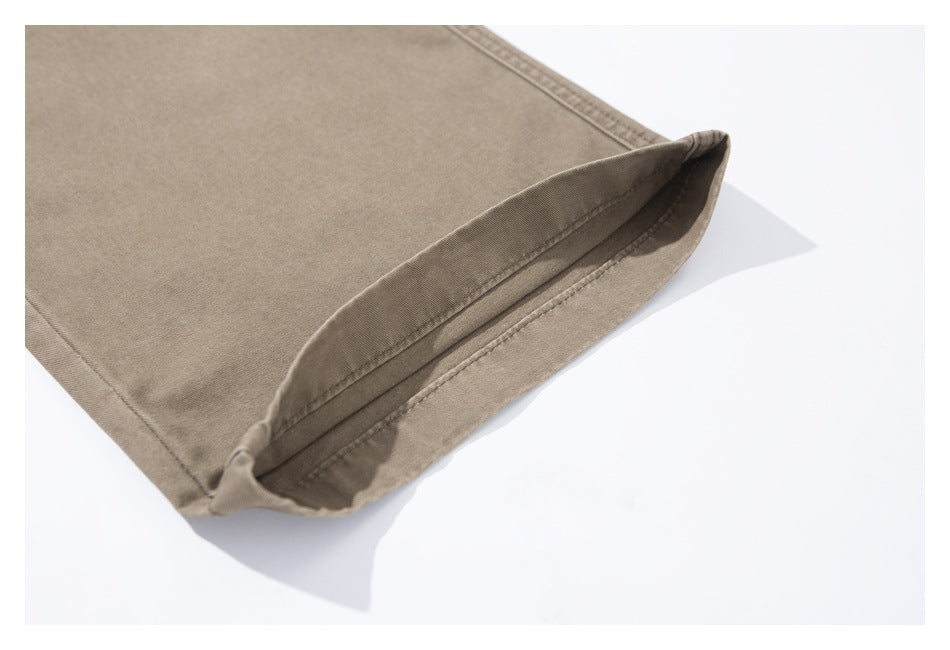 Close-up of the stitched hem on a taupe pants leg, turned up to show the inside.