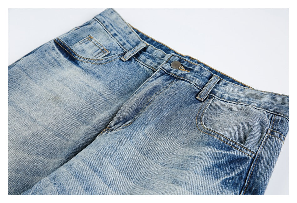 Close-up of the jeans' front waist, button, belt loops, coin pocket, and faded blue wash.
