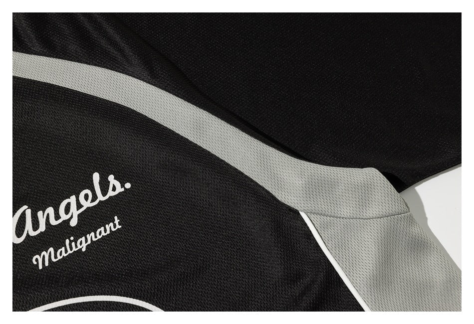 Close-up of a black garment with light gray paneling and part of a white printed design.