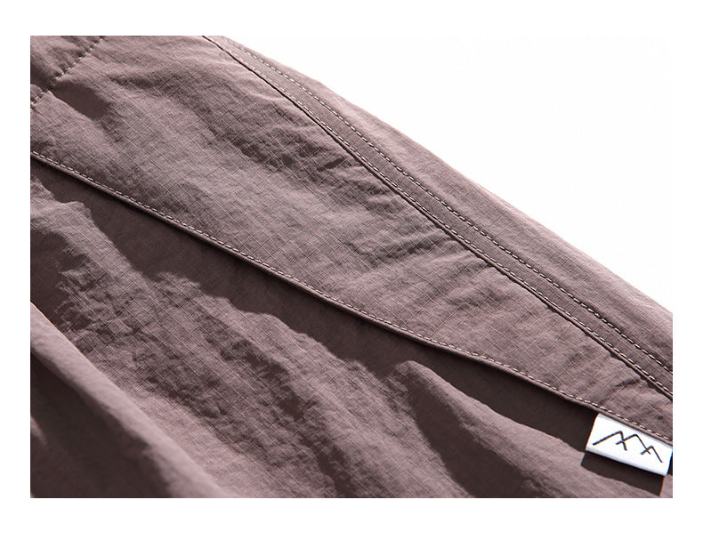 Close-up of mauve pants fabric, double stitching, and a small sewn-in label.