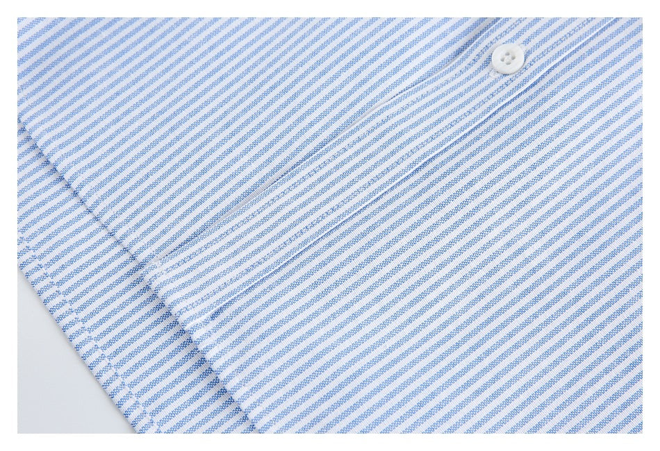 Close-up of blue-and-white striped fabric with a white button and overlapping stitched panels.