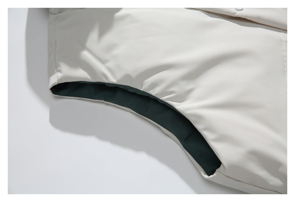 Close-up of the vest's armhole, showing dark green lining inside the ivory edge.