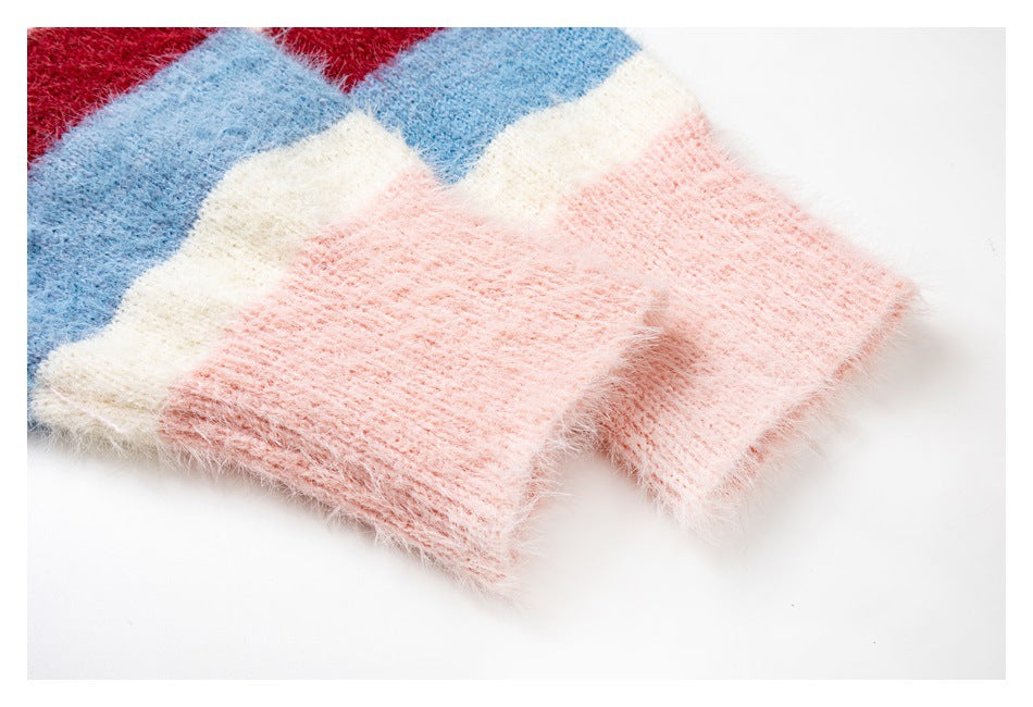 Close-up of a fuzzy pink cardigan cuff beside broad blue, cream, and red stripes.