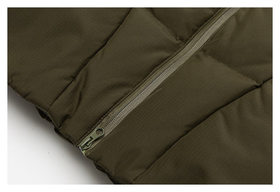 Close-up of an olive jacket's diagonal zipper and stitched padded panels.