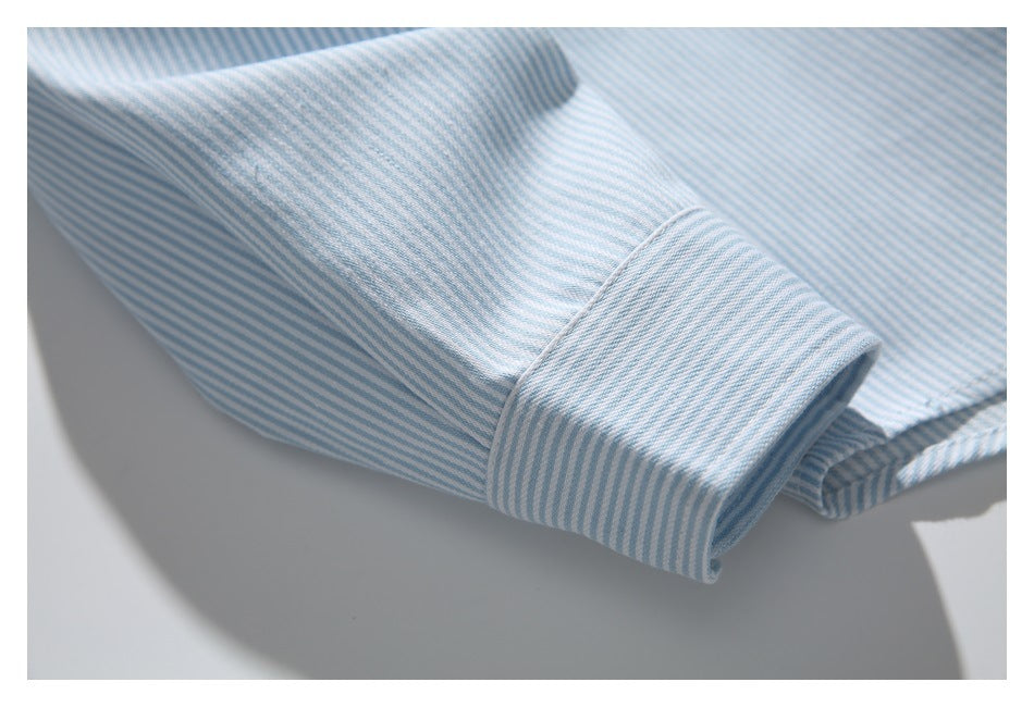 Close-up of a light blue and white striped shirt sleeve with a buttoned cuff.