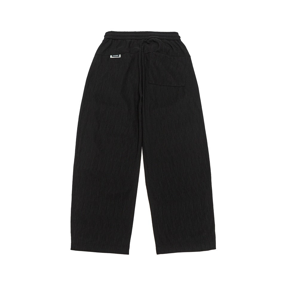 Back view of black wide-leg pants with an elastic waistband and rear pockets, shown flat on white.