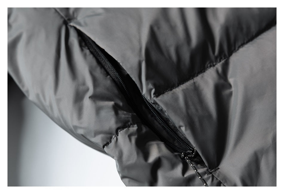 Angled close-up of a black zippered pocket on a dark gray quilted jacket.