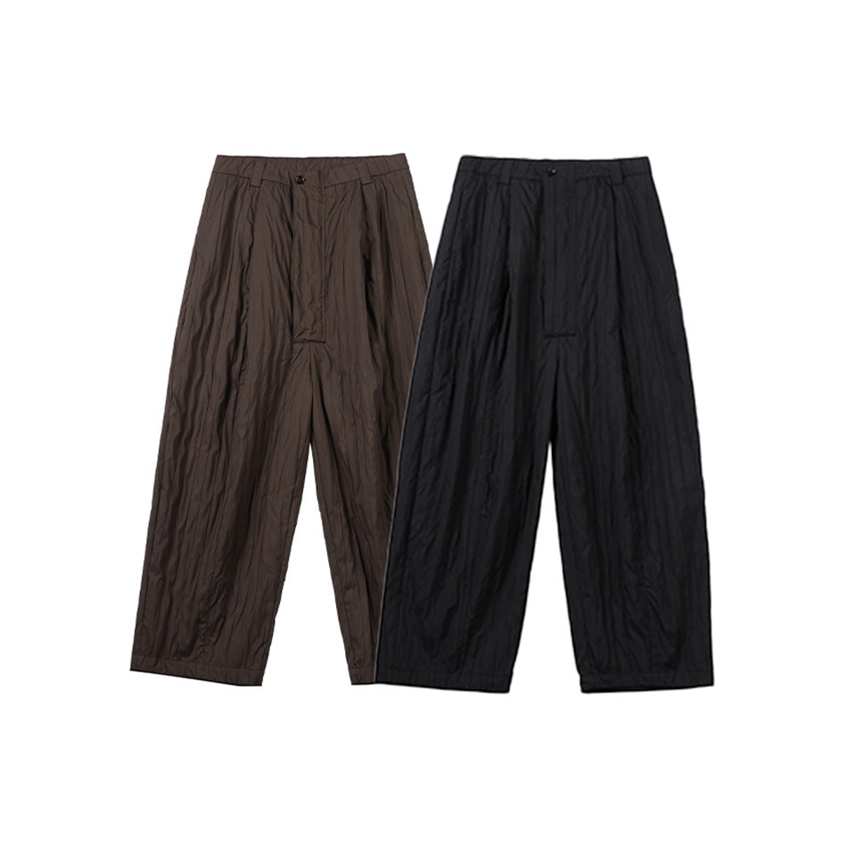 Full-length front view of wide-leg pleated trousers in dark brown and black.