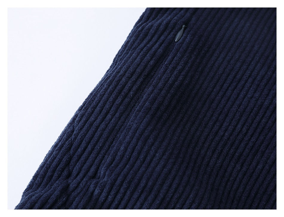 Close-up of dark navy ribbed fabric with a small zipper pull near the edge.
