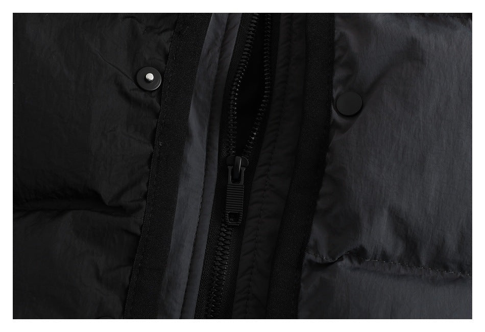 Close-up of the jacket’s central black zipper, snap buttons, and black and charcoal fabric panels.