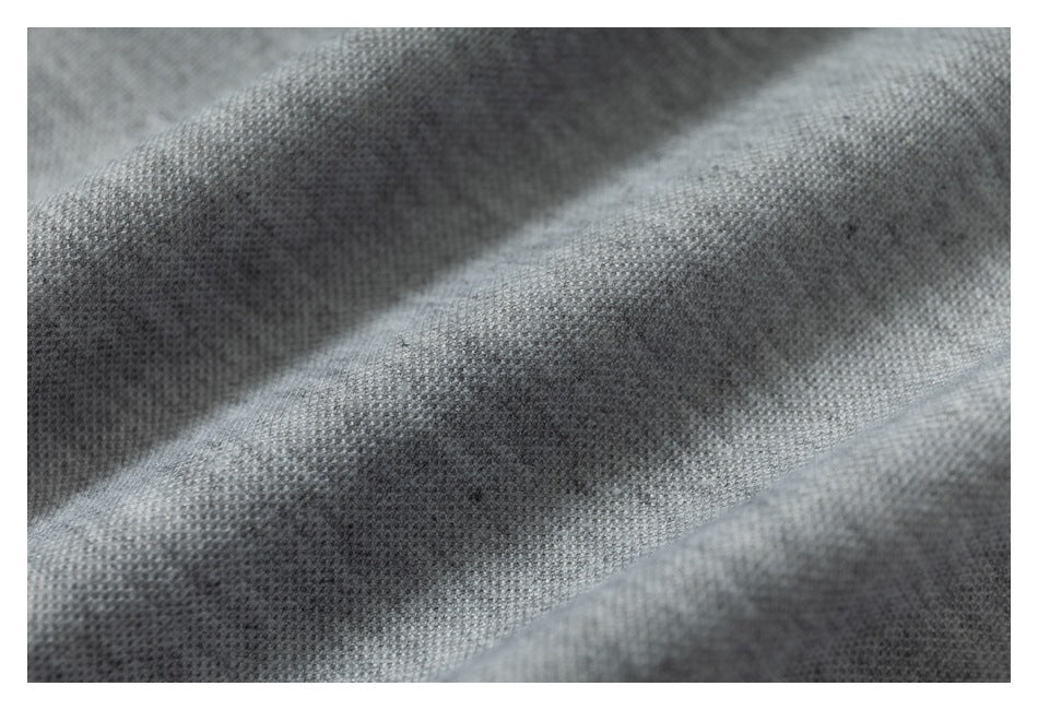 Macro view of textured heather gray fabric gathered into soft folds.